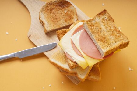 Close up - Stack of sandwich ham cheese on wooden pad.