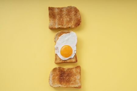 Three home made organic sliced bread grill with fried egg on top.の写真素材