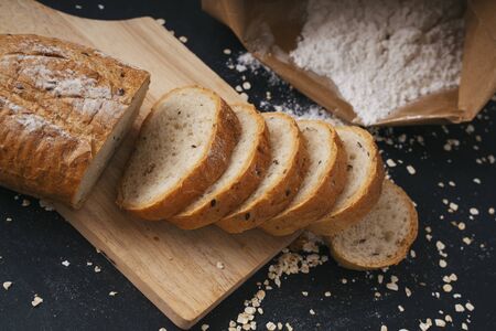 Group of many type of bread on a plate. Top view. Over black background.の写真素材