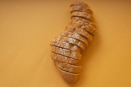 Top view - Sliced of loaf bread over orange background.