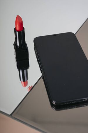 Red lipsticks in black box and smartphone. Luxury concept.の写真素材
