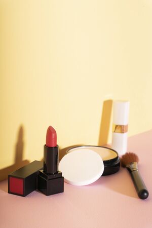 Professional makeup brushes and tools, make-up products set on bright yellow wall.の写真素材