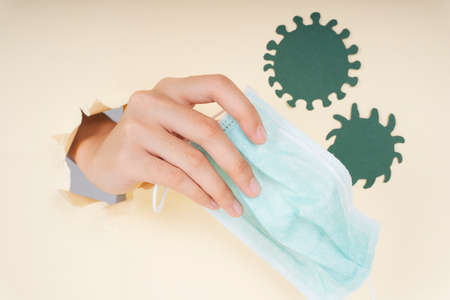 Woman hand holding doctor surgical mask to prevent coronavirus.