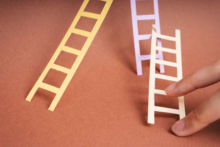 Two finger climbing paper ladder. Future career and job concept.の写真素材