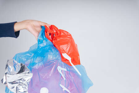 Hand of woman recycling plastic bag waste isolate over white background.の写真素材