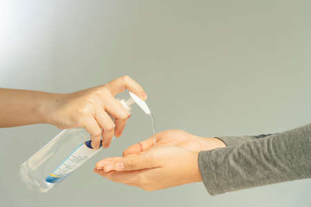 People applying using putting alcohol gel on hands.