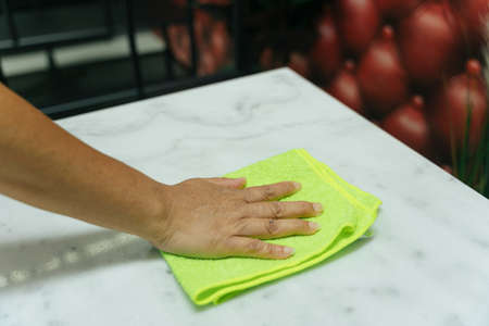 Hand of woman cleaning dinning table with rack cloth. Covid-19 Coronavirus prevention.の写真素材