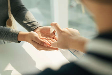 People applying using putting alcohol gel on hands.の写真素材