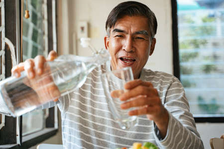 Cropped image of pastel food carrier in a man's hands while he waiting for a monk in the morning to...