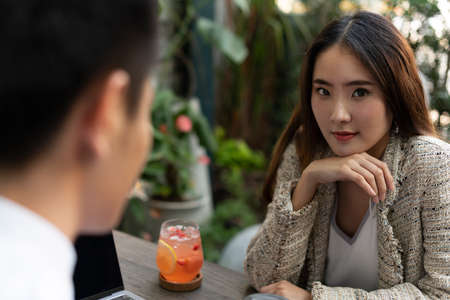 Beautiful asian woman dating with business guy at cafe. Dating with a man.の写真素材