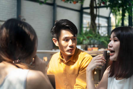 Asian thai woman working with laptop on table inside coffee shop.
