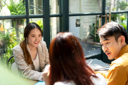 Excited surprise asian woman on red dress opening the present gift box that she got it from her boyfriend.の写真素材