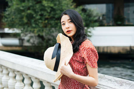 Asian beautiful woman wearing orange shirt talking to someone at coffee shop cafe.