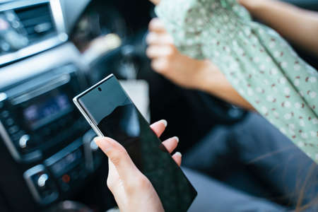 Cheerful handsome young asian thai man wearing jeans shirt driving a car on the road.の写真素材