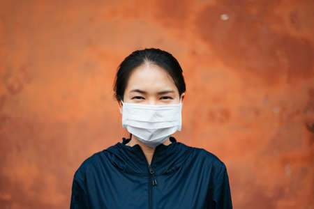 Cheerful smiling asian woman wearing eyeglasses holding a cup of coffee in the morning.