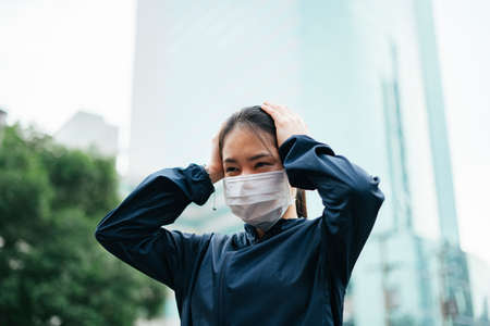 Cheerful smiling asian woman wearing eyeglasses holding a cup of coffee in the morning.の写真素材