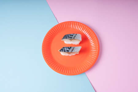 Top view - Saba sushi on red plate over pastel background.
