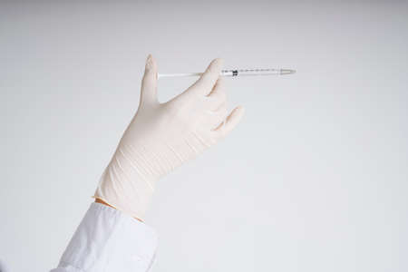 Doctor plastic gloves hand holding using syringe isolate over white background.