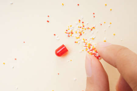 Human hand grabbing Broken red pill capsules and molecules.の写真素材