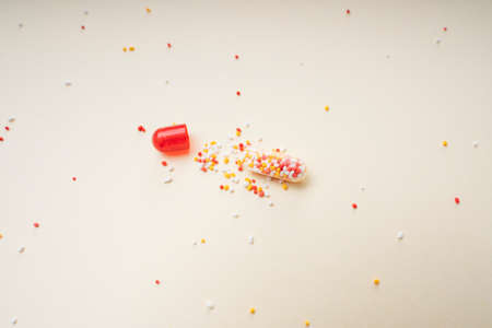 Broken red pill capsules and molecules as medical concept.の写真素材