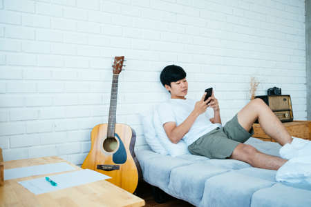 Musician guy replay his record in his phone about his written song.の写真素材