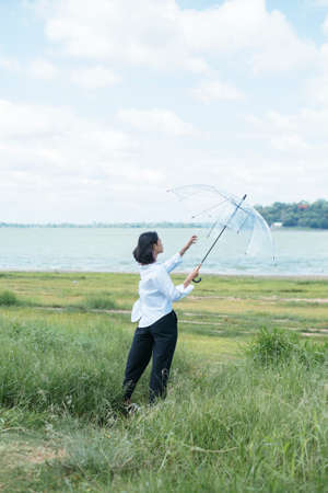 Young asian woman holding transparency umbrella, flying with umbrella.