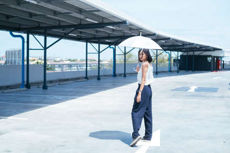 Sexy young asian woman with white umbrella at parking lot - Summer fashion collection.