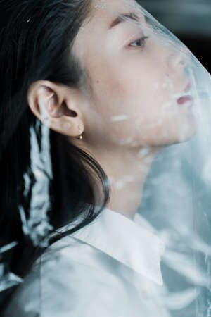 Right side of the woman in plastic bag with chin up.の写真素材