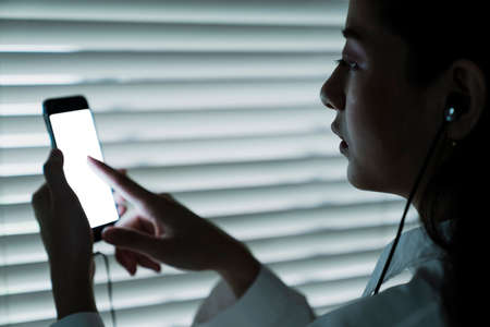 Long hair woman choose the song in her smartphone.