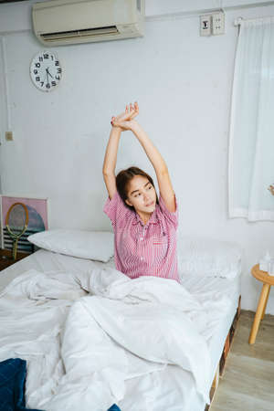 Long hair woman wake up in the morning and stretching.の写真素材