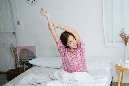 Long hair woman wake up in the morning and stretching.の写真素材