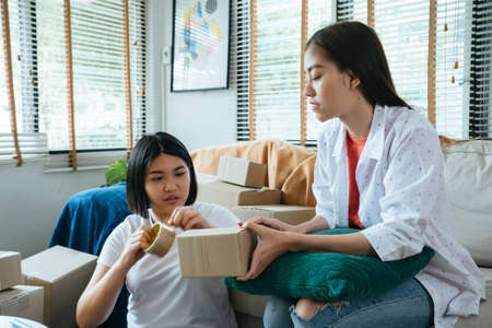 Two Thai girl in living room packing the parcel to send to customer online shopping.の写真素材