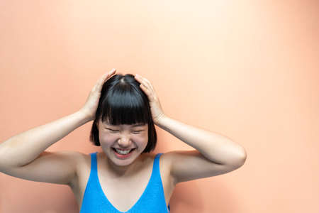 Cheerful asian thai woman bob hairstyle smiling with happiness isolated over biege background....