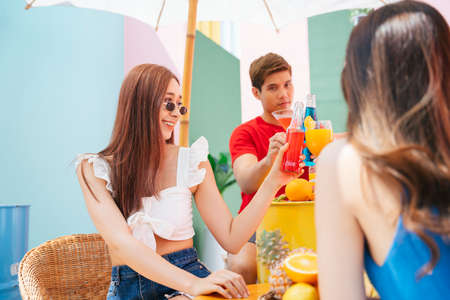 Happy young people enjoy drink and food in summer party. Fruits juice non alcohol.