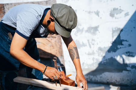 Craftmans measure the plank and use the shaving to make it thin.の写真素材