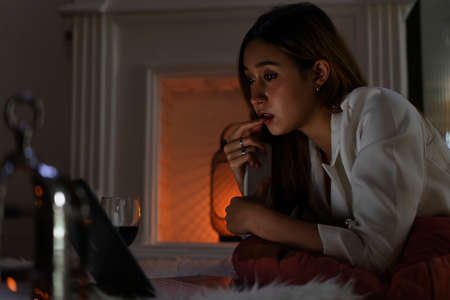 Woman watching movie or series on laptop at night.