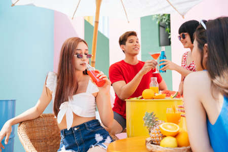 Happy young people enjoy drink and food in summer party. Fruits juice non alcohol.の写真素材