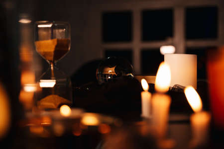 Crystal ball in fortune teller room. Dark room with candles light up.の写真素材