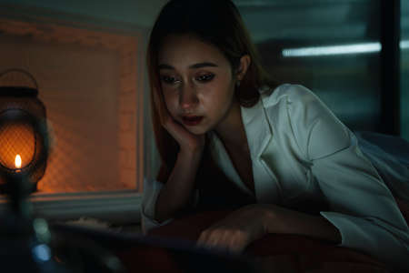 Woman watching movie or series on laptop at night.