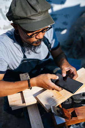 The carpenter man make the frame from wooden by himself, take a photo of work.の写真素材