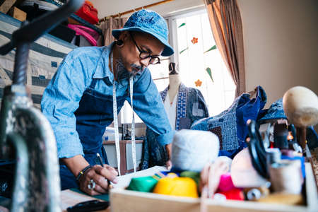A man in blue clothes and apron focus on his clothing pattern and think hoe to get better.の写真素材