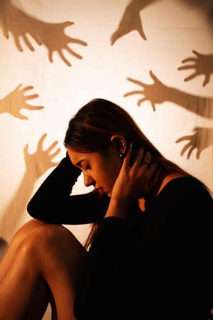 Beautiful mixed race woman sitting among the ghost hands.の写真素材