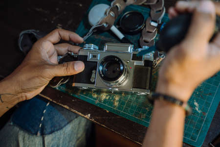 A man fix the film camera and clean the dust on the lens then assemble all the part together.の写真素材