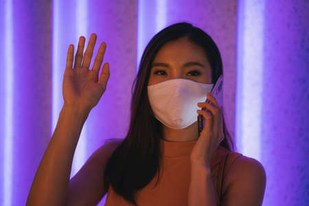 Beautiful asian thai woman wearing cotton talking on the phone. Covid-19 outbreak.
