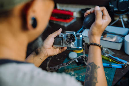 A man fix the film camera and clean the dust on the lens then assemble all the part together.の写真素材