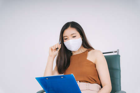 Thoughtful Beautiful asian thai businesswoman planning working process on a chair isolate over white...