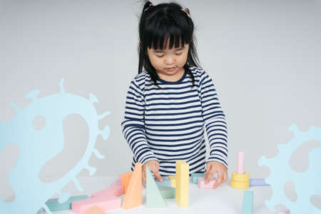 Pretty asian thai kid woman playing with toy block.