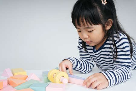 Pretty asian thai kid woman playing with toy block at home.の写真素材
