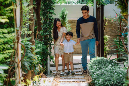 Asian thai family holding son hands walking into school.の写真素材