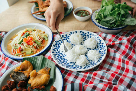 Hand of woman eating rice noodle with fork. Isan food concept.の写真素材
